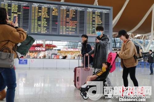 旅客帶著孩子前往辦票柜臺辦理登機(jī)手續(xù)?！∫罅⑶?攝