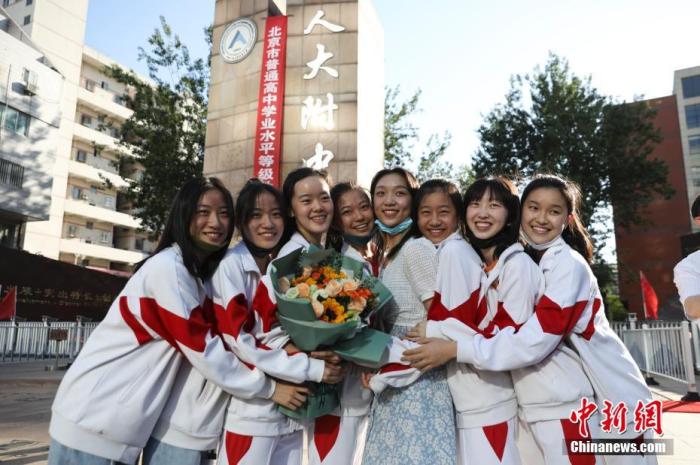 資料圖：6月10日，在北京人大附中高考考點(diǎn)外，考生們相擁拍照留念。當(dāng)日，北京市2021年高考結(jié)束。　 <a target='_blank'  data-cke-saved- ><p  align=